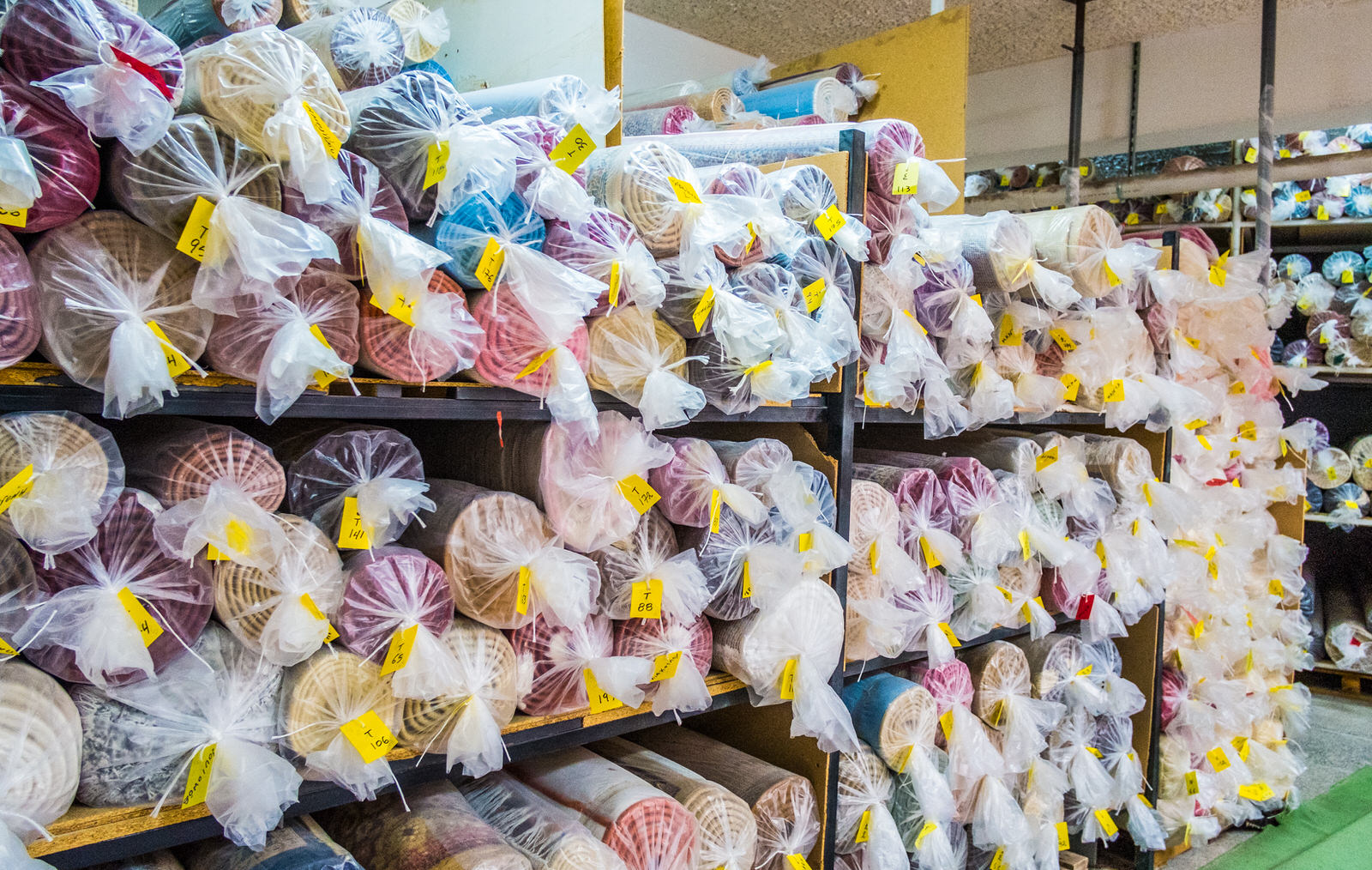 Αποθηκευτικός χώρος χαλιών: ράφια γεμάτα με καθαρά, συσκευασμένα χαλιά