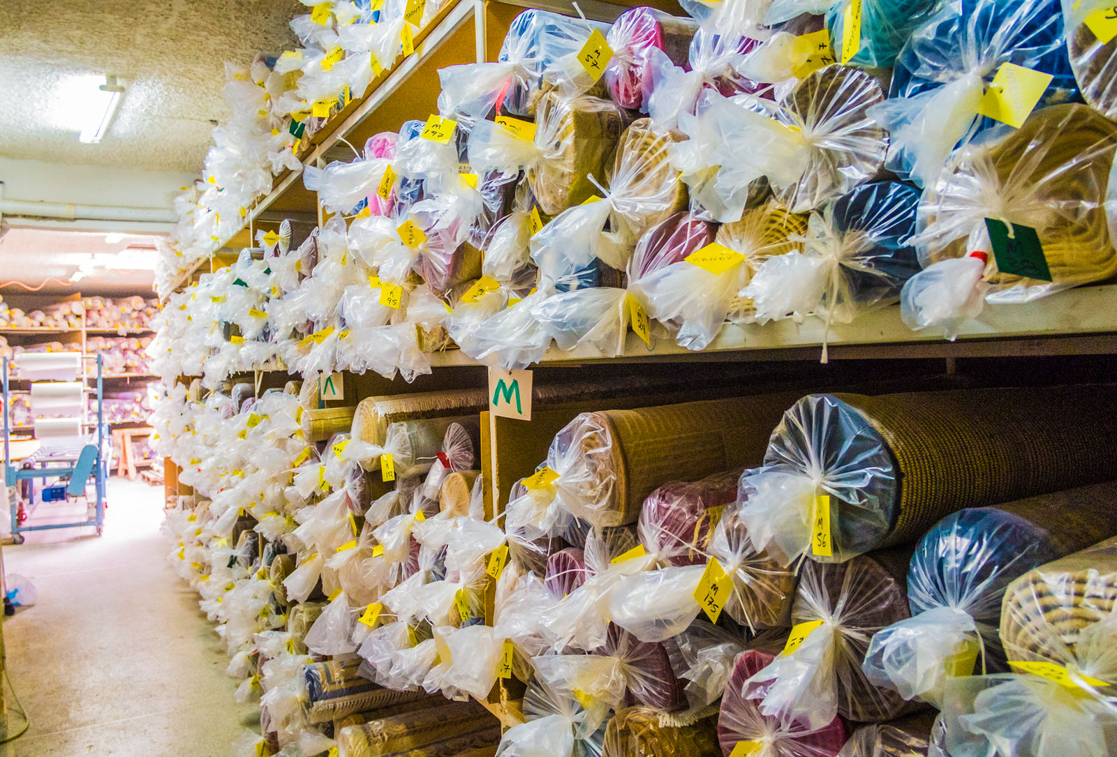 Αποθηκευτικός χώρος χαλιών: ράφια γεμάτα με καθαρά, συσκευασμένα χαλιά