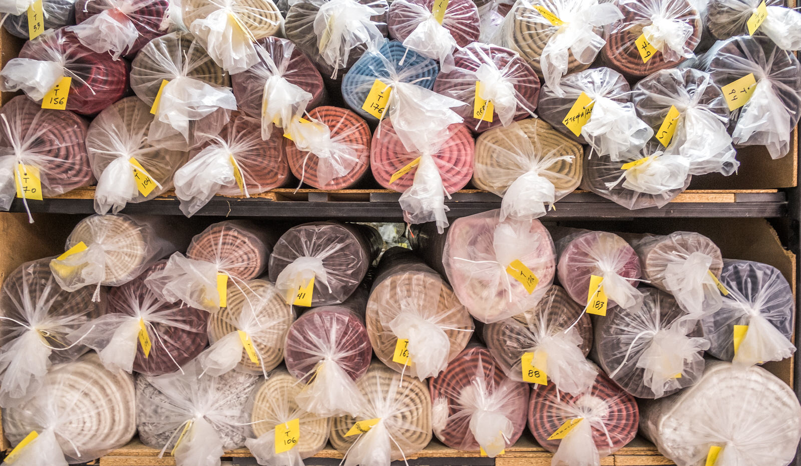 Αποθηκευτικός χώρος χαλιών: ράφια γεμάτα με καθαρά, συσκευασμένα χαλιά